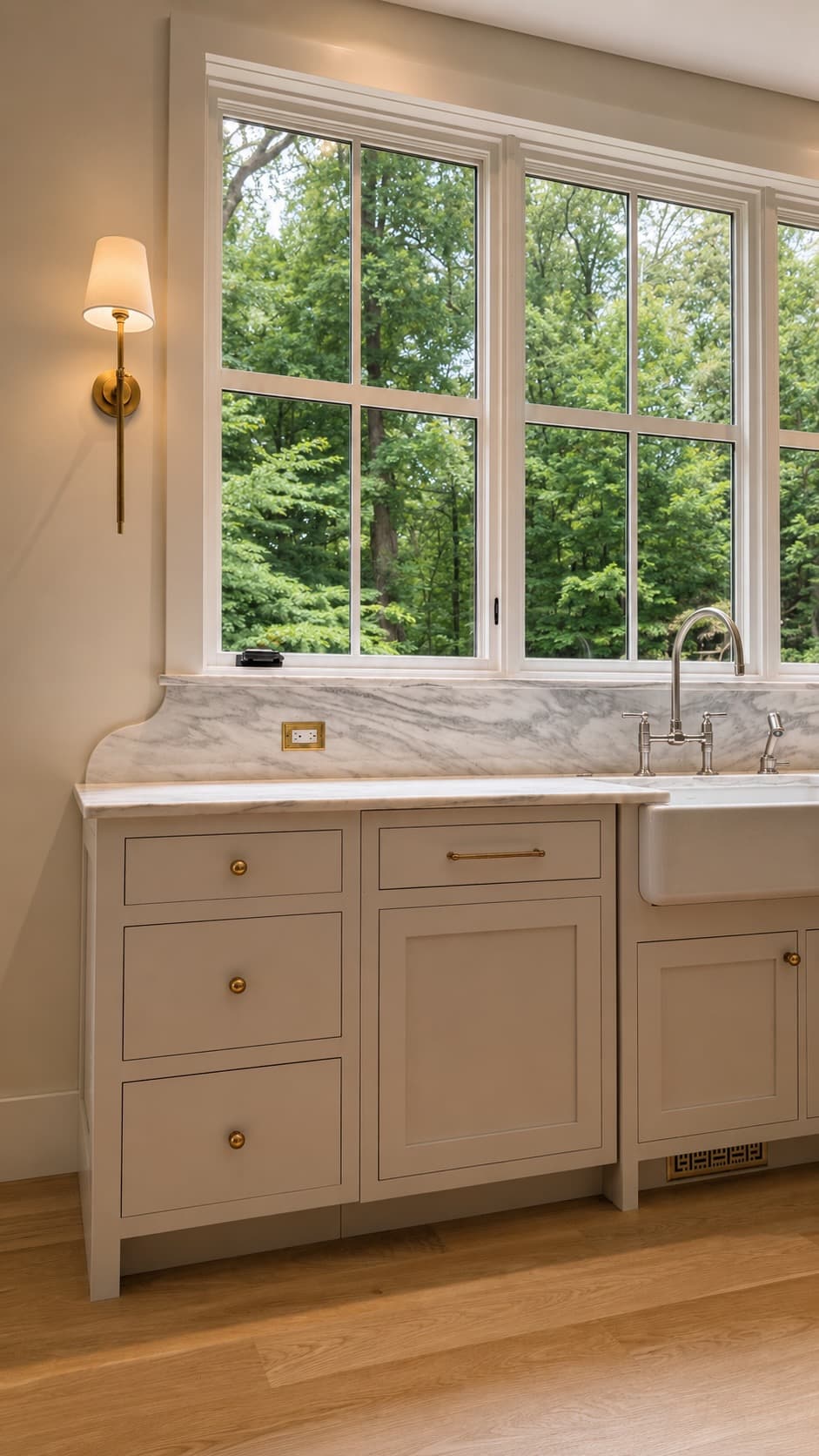 Kitchen cabinetry with brass hardware and marble countertop